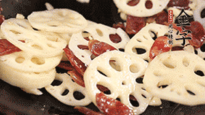 依次下香腸片、藕片翻炒均勻，加適量清水燜熟。