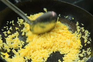 大火加熱炒鍋，再入油，燒到四至五成熱時倒入雞蛋液，在未凝結(jié)之前，加米飯煸炒，不停翻炒并用鍋鏟將成塊的米飯碾開、撥散。