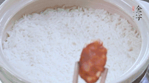 煮開(kāi)后轉(zhuǎn)小火，當(dāng)米飯出現(xiàn)小孔時(shí)，鋪上金字麻辣香腸。