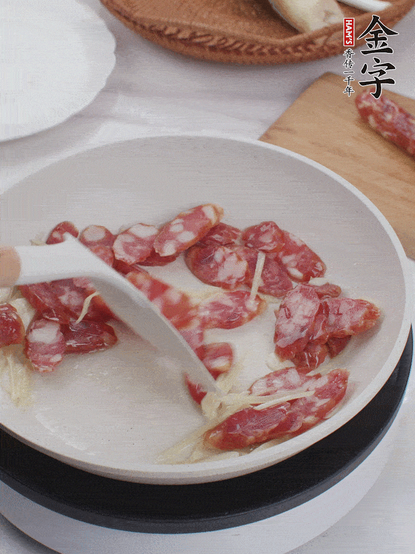 油溫3成熱時(shí)，下姜絲、蒜片、香腸炒出油脂。