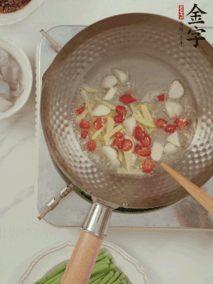 油7成熱時(shí)，下大蒜粒、姜絲、小米辣煸香。