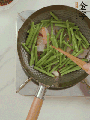 下掰好的缸豆段翻炒，略燜煮。
