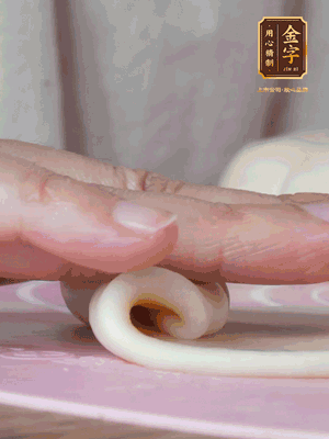 做面劑 油皮按扁，中間包入一個油酥，邊緣收緊捏死。包好的面劑按扁，用搟面杖搟壓成橢圓形。從底部向上卷成筒狀，用保鮮膜蓋好松弛15分鐘，再把筒狀縱向搟壓成長條狀。再卷一次，松弛20分鐘